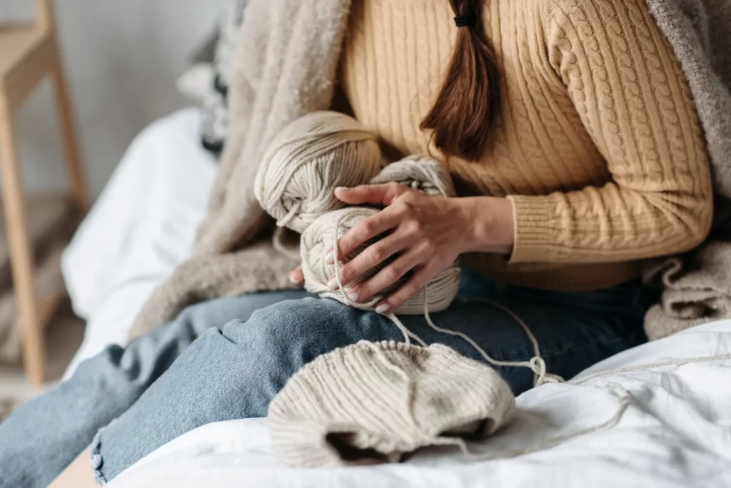 Threads for knitting in the hands of a woman